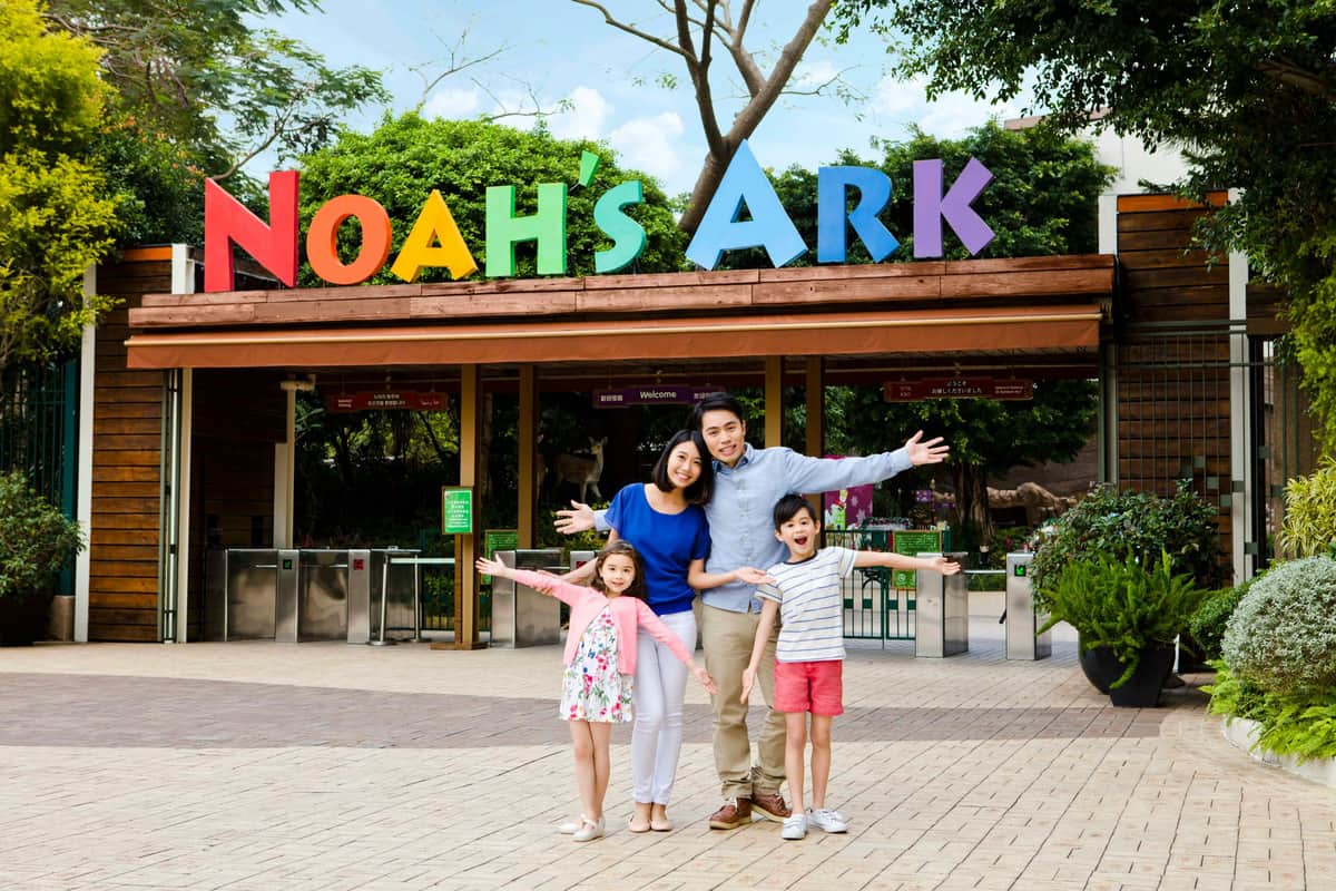 Noah's Ark: Entry Ticket A family of four, standing with arms outstretched, poses in front of an entrance sign that reads "Noah's Ark."