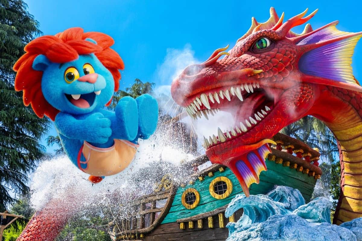 A blue puppet-like character is launched near a red dragon's head, with a pirate ship and water splashes in the scene.