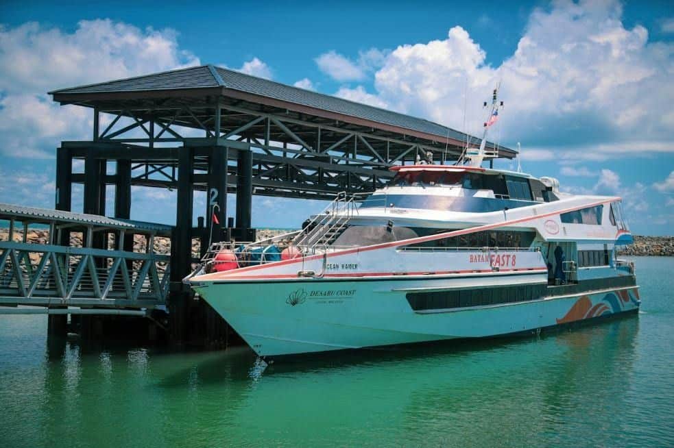 A passenger boat docked at a pier under a sunny sky, with the name "Bali Fast 8" visible on its side.