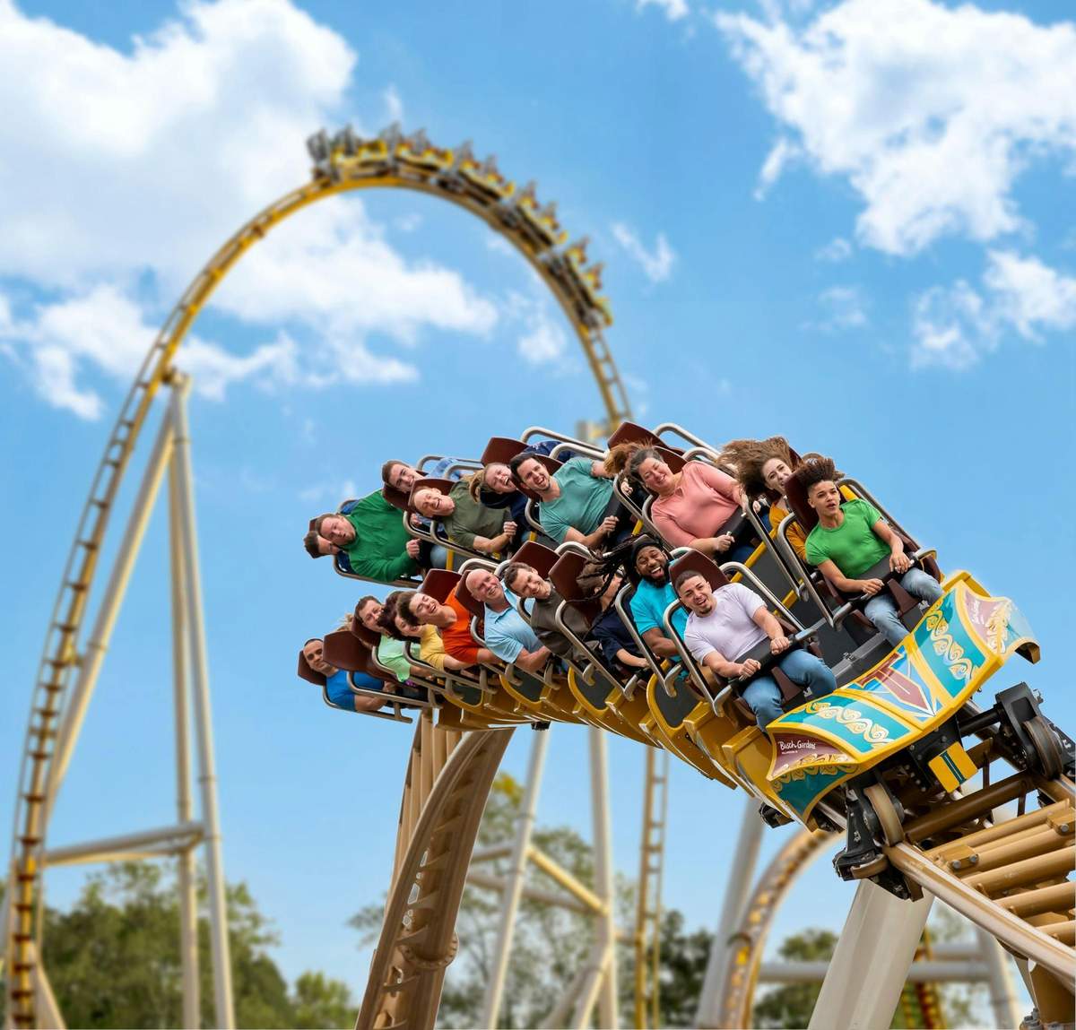 Busch Gardens Williamsburg: Entry Ticket People on a rollercoaster ride down a steep curve with hands raised against a backdrop of blue sky and scattered clouds.