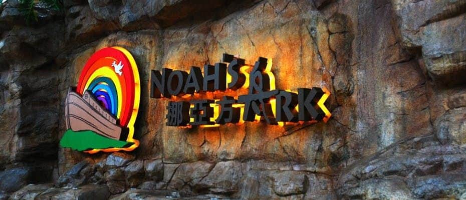 Sign with "Noah's Ark" and Chinese characters, featuring a rainbow and ark graphic, mounted on a rocky wall.