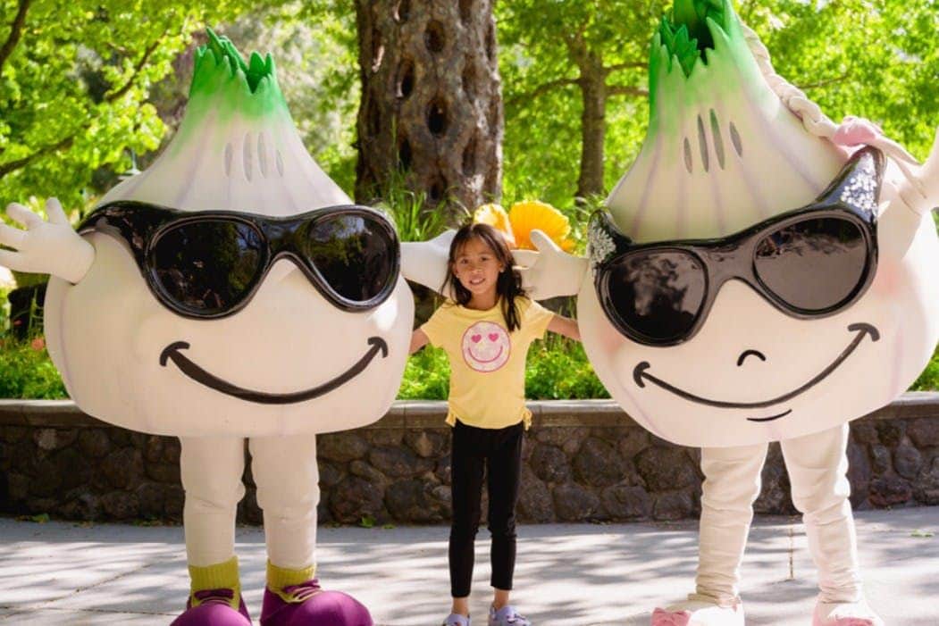 Little girl standing between the supplier's mascots, Gil & Roy.