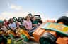 A family enjoys a ride on a colorful roller coaster under a clear blue sky.