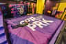 SuperPark Philippines in Quezon City Park Ticket (Cebu City) A person lies on a purple crash mat with white text in an indoor trampoline park with colorful walls and cushioned surfaces.